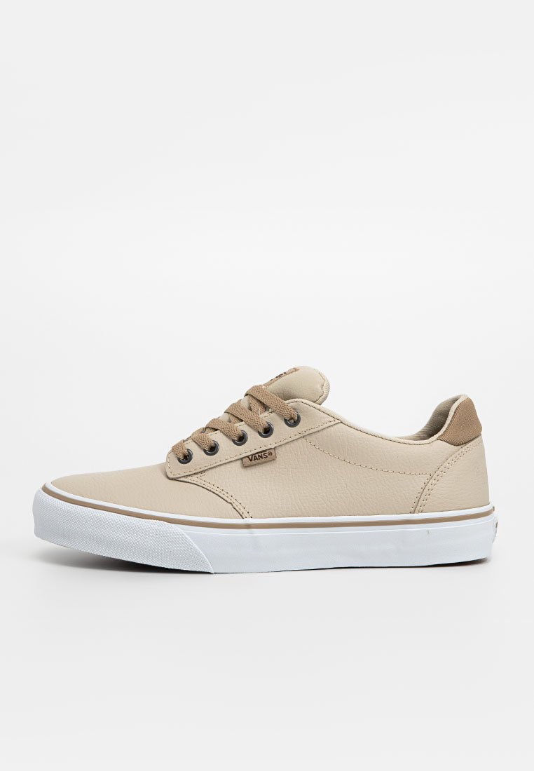 Zapatillas beige de cuero texturizado, con acentos marrones, cordones redondos y una suela de goma blanca con un borde en contraste.