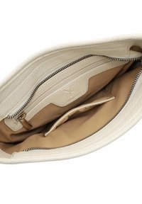 Interno di una borsa bianca in pelle con una texture liscia, presenta una tasca con zip e foderatura beige. Include scomparti aggiuntivi per l'organizzazione.