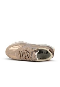 Scarpa sportiva marrone chiaro realizzata in materiale scamosciato e sintetico, con punta arrotondata, colletto imbottito e lacci piatti. Dettagli metallici arricchiscono il design.