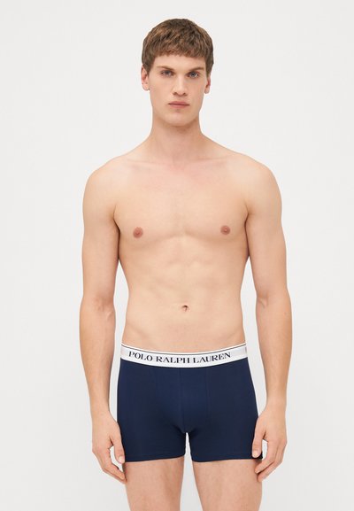 Temno modri bokserji iz bombaža, z belim pasom s logotipom "POLO RALPH LAUREN". Gladka tekstura, prilegajoča zasnova in srednje dolžine.