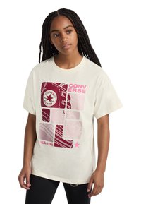 Cream cotton t-shirt featuring a graphic design with maroon and pink accents, including a Converse logo and various rectangular patterns.