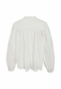 Valkoinen pusero, jossa pitkät, pölhöhat hihat ja kerätty yläosa. Valmistettu kevyestä kankaasta, jossa on yksinkertainen takasauman yksityiskohta.