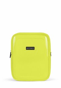 Geel harde koffer met verticale ribbels, prominent zwart logo, dubbele rits en een gladde, glanzende afwerking. Compact rechthoekig ontwerp.