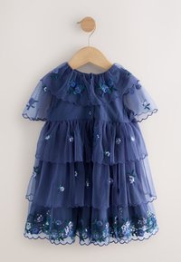 Vestido azul marino de capas hecho de tul, con flores bordadas, bordes ondulados y cierre de botones en la parte trasera.