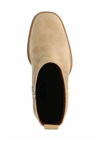 Stivale alla caviglia in suede color sabbia con texture liscia, punta rotonda e zip laterale; suola piatta e cuciture lungo il bordo.