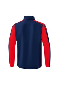 Giacca con zip navy e rossa, colletto alto, maniche lunghe e design aderente; presenta lavorazione a blocchi di colore sulle maniche e una texture liscia.