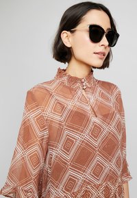 Le Specs CALIENTE  - Zonnebril - black/gold-coloured