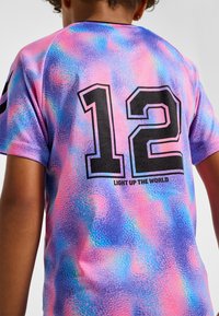 Kortärmad T-shirt i ett livfullt rosa och blått tie-dye-mönster, med svart "12" och texten "LIGHT UP THE WORLD" på ryggen.