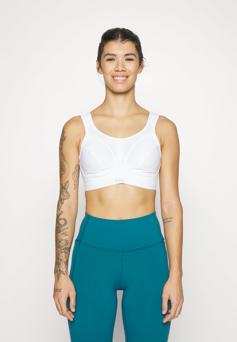 Hvit sports-BH med brede stropper og en rund hals, med et teksturert design. Kombinert med teal høy midje leggings.
