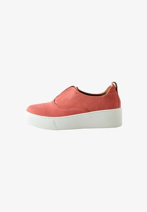 Korálovo sfarbená slip-on teniska s hrubou bielou platformovou podrážkou, nízkym strihom pri členku a ťahacou pätkou, navrhnutá na bežné nosenie.