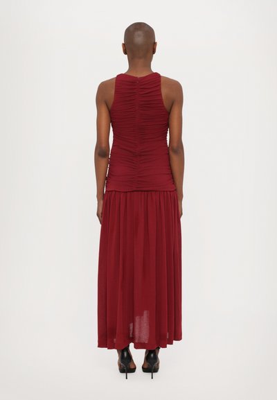 Maxi-Kleid in tiefem Rot mit einem taillierten, gerafften Oberteil und fließendem Rock. Verfügt über ein ärmelloses Design und einen Reißverschluss am Rücken. Sanfte Textur.
