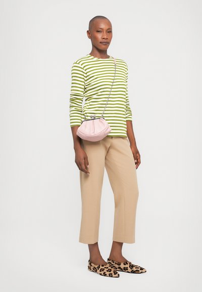 Vihreä-valkoiraitainen pitkähihaisia paita, beige lyhyet housut, vaaleanpunainen käsilaukku hopeisilla yksityiskohdilla ja leopardikuvioiset slip-on-kengät.