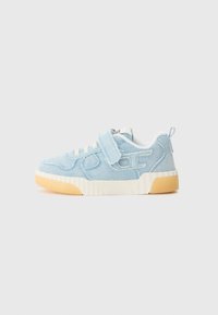 Baskets en denim bleu clair avec une tige texturée, lacets blancs, bande Velcro et semelle en caoutchouc. Présente des accents découpés sur les côtés.