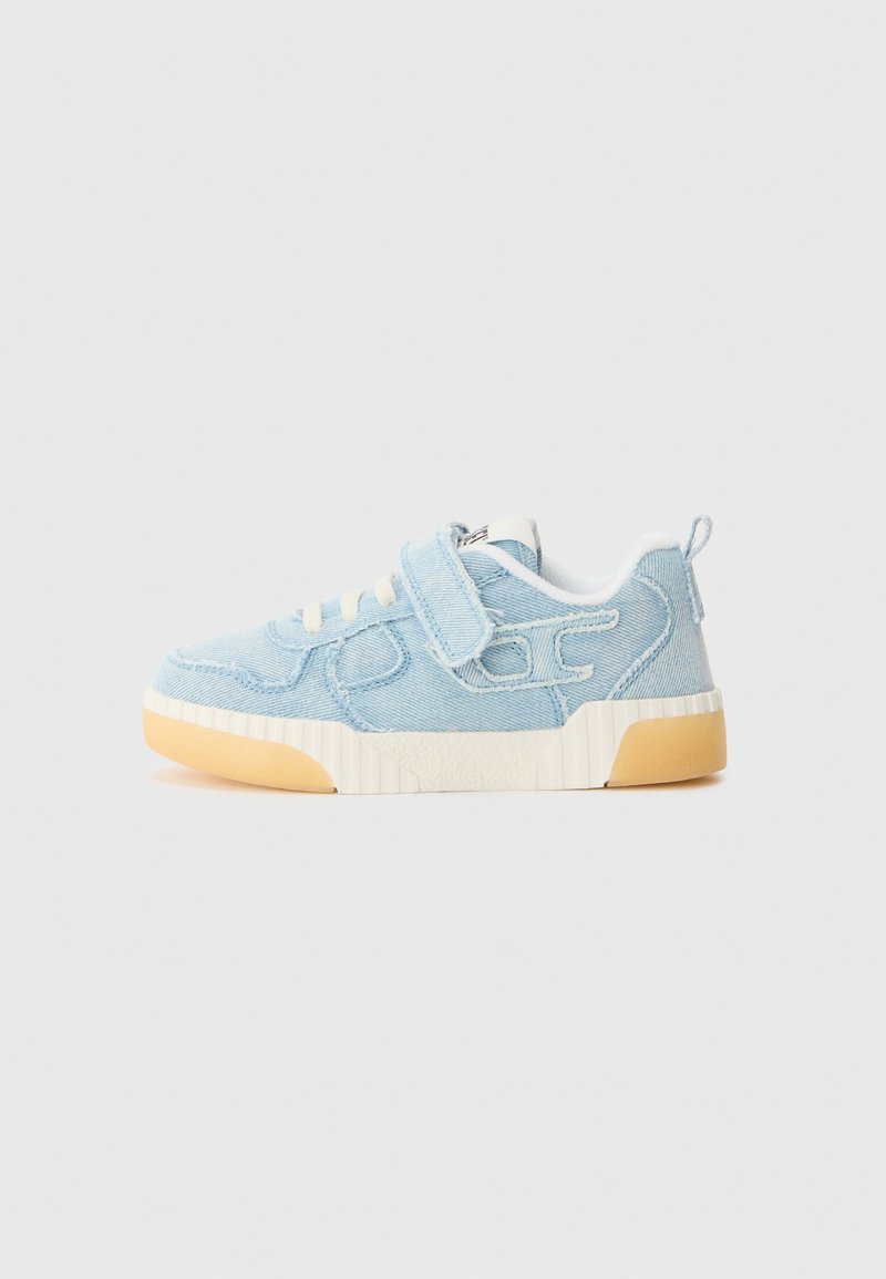 Baskets en denim bleu clair avec une tige texturée, lacets blancs, bande Velcro et semelle en caoutchouc. Présente des accents découpés sur les côtés.