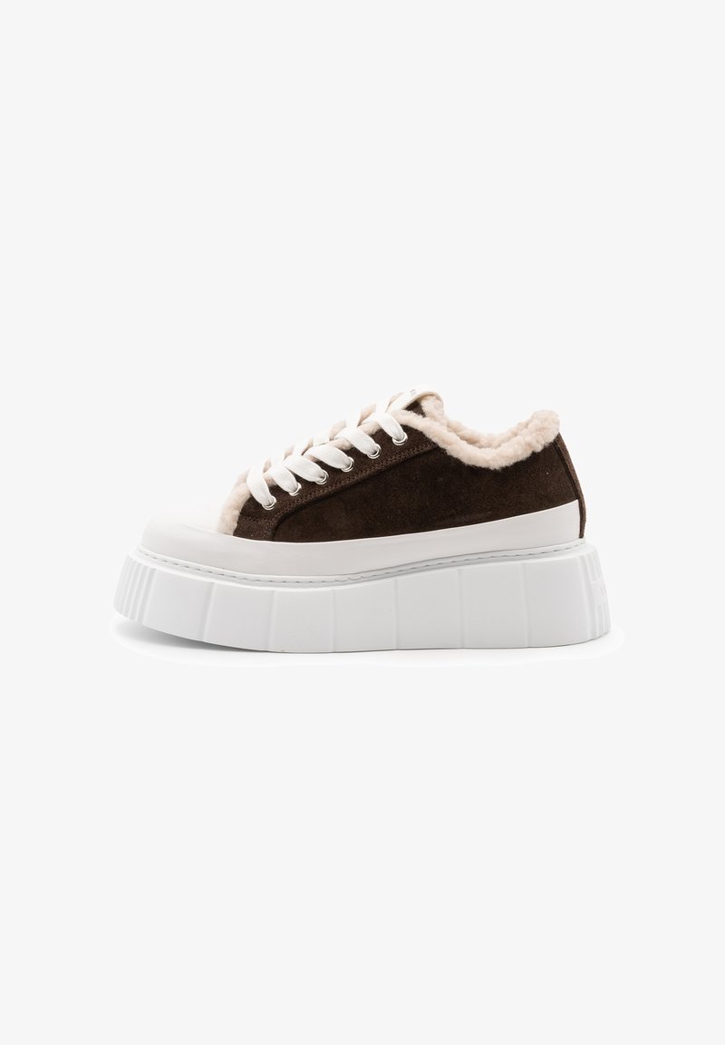 Sneaker in suede marrone con suola piatta in gomma bianca, caratterizzata da una morbida fodera crema e lacci bianchi, design a taglio basso e punta arrotondata.