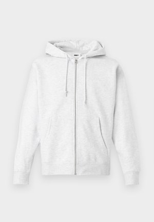 Light gray zip-up hoodie made of soft fabric. Features a drawstring hood, two front pockets, and ribbed cuffs, with a subtle logo on the chest.