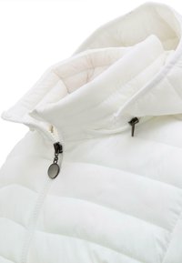 Giacca a vento bianca con colletto alto, caratterizzata da una texture trapuntata, chiusura con zip e un tirazip in metallo scuro per un tocco di dettaglio.