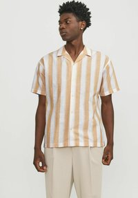 Korte mouw knoopshirt in lichtbeige en witte strepen. Gemaakt van een lichte stof, met een insnijding op de kraag en een rechte zoom.