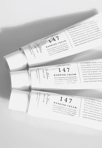 Søte hvite aluminiumrør med "147 Barrier Cream" stablet, med svart tekstetikett som viser produktdetaljer og sølvfargede skrulokk.
