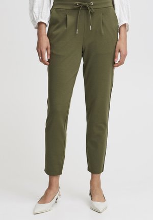 Pantalons de jogging vert olive avec une taille élastique, des plis à l'avant, des accents de fermeture éclair sur les côtés et une coupe tapered.