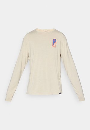 Beige long-sleeve Patagonia shirt with small blue and red logo on the upper left chest, featuring a stylized design and text.