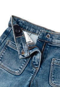 Jeans in denim con chiusura a zip e bottone, con una vita blu scuro, cuciture visibili e tasche. Il tessuto ha una texture sbiadita.