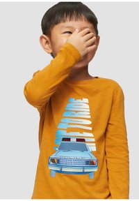 Langarm geel shirt met een blauwe graphic van een politieauto met rode lichten en de tekst "LIFE TO RIDE" in vette, verticale letters.