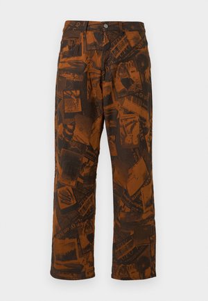 Pantalones marrones con patrón que presentan un collage de diseños oscuros, forma de pierna acampanada, cierre estándar con botón y cremallera, y estilo de cinco bolsillos.