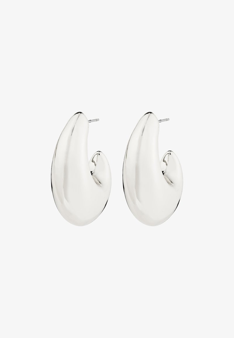 Paire de boucles d'oreilles en métal argenté brillant avec un design lisse et courbé et des fermoirs à poussette sur fond blanc.