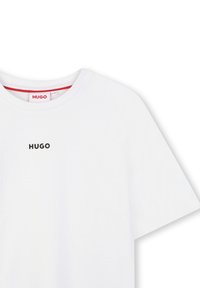 Witte katoenen T-shirt met een ronde halslijn en korte mouwen. Bevat een zwart 'HUGO'-logo op de borst en een rood label bij de kraag.