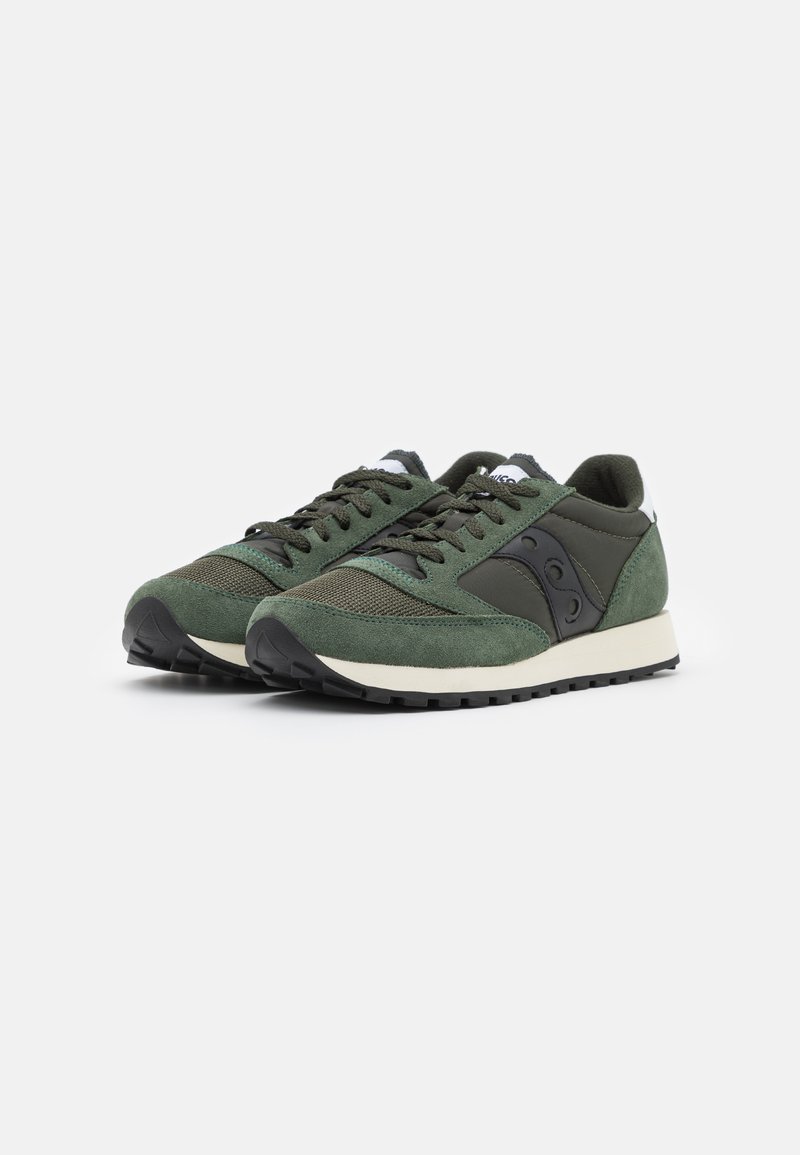 Zapatillas verdes con parte superior de ante y malla, acentos negros en los laterales y una entresuela blanca. Presentan cordones redondos y una suela de goma texturizada.
