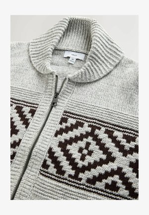 Hallitatud hall kardigan kõrge kaelusega, millel on tõmblukk ja tumepruunid mustrid rinnaosas.