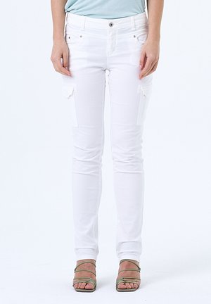 Witte stretch cargobroek met slim fit, met patchzakken op de dijen en een minimalistisch ontwerp. Gecombineerd met groene sandalen met bandjes.