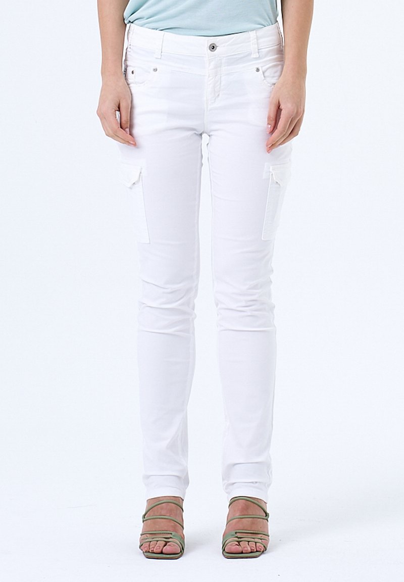 Pantalons cargo blancs extensibles avec coupe slim, dotés de poches à patch sur les cuisses et d'un design minimaliste. Associés à des sandales vertes à brides.