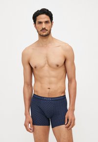 Boxer briefs with a navy patterned design, elastic waistband featuring the Levi's logo, and a snug, comfortable fit. Smooth fabric texture.