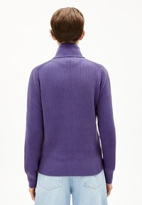 Lila gerippter Strickpullover mit hohem Kragen und langen Ärmeln, der einen taillierten Saum und ein strukturiertes Muster aufweist.