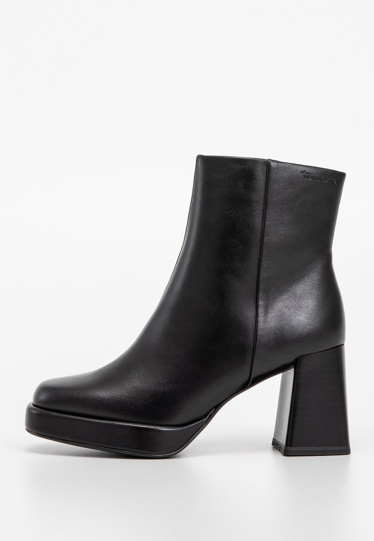 Zwarte enkelboot van soepel leer, met een blokhak en een ronde neus. Het ontwerp heeft een subtiele naad en minimalistische details.