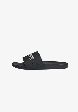 Black slide sandals with a textured strap, featuring three horizontal grooves and white logo text. Made from smooth, durable material.