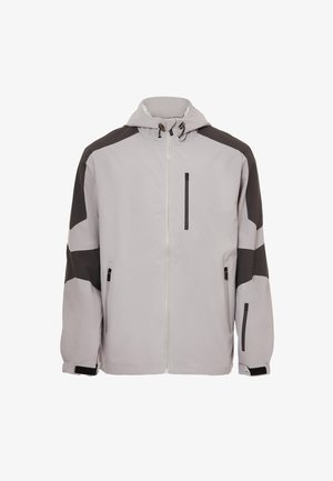 Lys grå jakke med sorte detaljer, der har hætte, frontlynlås og flere lynlåslommer. Glat tekstur og sporty design.