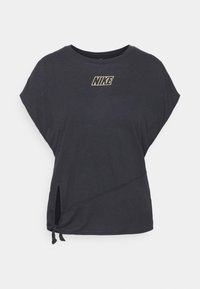 Camiseta negra de manga corta con cuello redondo, con un corte diagonal y un detalle de lazo en el dobladillo. Logo dorado de Nike en el pecho.