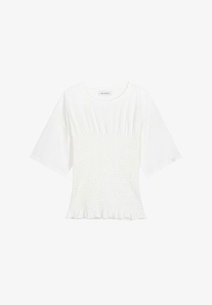 Bela majica s kratkimi rokavi z nabrano teksturo v pasu in volanastim robom. Narejena iz mehkega materiala, ima okroglo ovratnico in oznako.