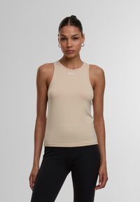 Nacktes ärmelloses Tanktop mit Rundhalsausschnitt, aus dehnbarem Material, mit einem kleinen weißen Logo auf der Vorderseite.