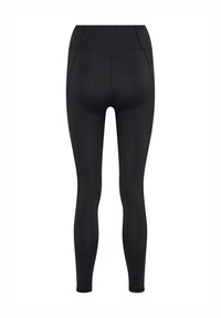 Leggings noirs avec une taille haute, texture lisse, design ajusté et détails de couture le long du dos pour un ajustement sculpté.
