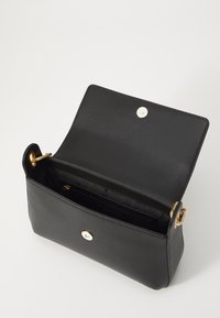 Borsa a mano in pelle nera con forma rettangolare, dettagli in metallo dorato e chiusura a scatto magnetico. L'interno presenta numerosi scomparti.