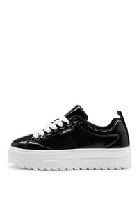 Schwarze Lackledersneaker mit weißen Schnürsenkeln, einer dicken weißen Sohle und strukturiertem Gummifußboden. Markenlogo auf der äußeren Seite.