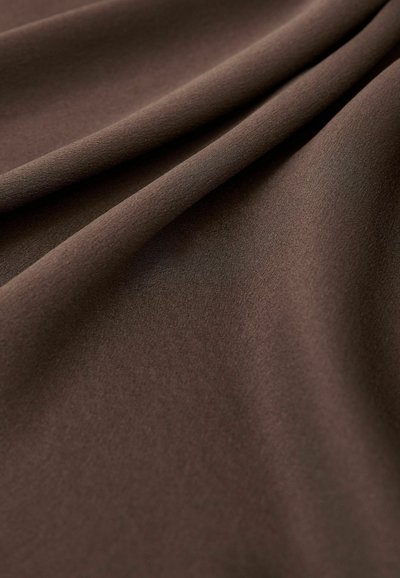 Smooth brown fabric with soft folds creating gentle shadows and highlights, emphasizing its texture and drape.