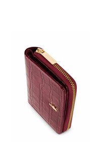 Burgundowy portfel na zamek błyskawiczny o fakturze krokodylej, ze złotymi elementami i kontrastowym zamkiem. Kompaktowy, prostokątny kształt z wytłoczonym detalem logo.