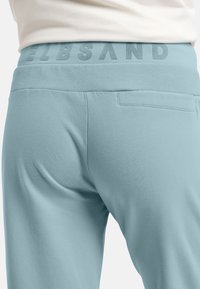 Helle blaue Jogginghose mit elastischem Bund und dezentem Branding. Verfügt über eine Gesäßtasche und eine weiche, glatte Textur.