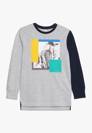 Grijze trui met lange mouwen en marineblauwe mouwen. Heeft een grafische print in gele, blauwe en groene geometrische vormen aan de voorkant.