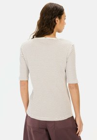 Gestreepte, kortarmige top in lichtbeige met donkerenbruine strepen. Zachte stof met een aansluitende vorm en ronde halslijn. Zomen zijn zichtbaar aan de achterkant.
